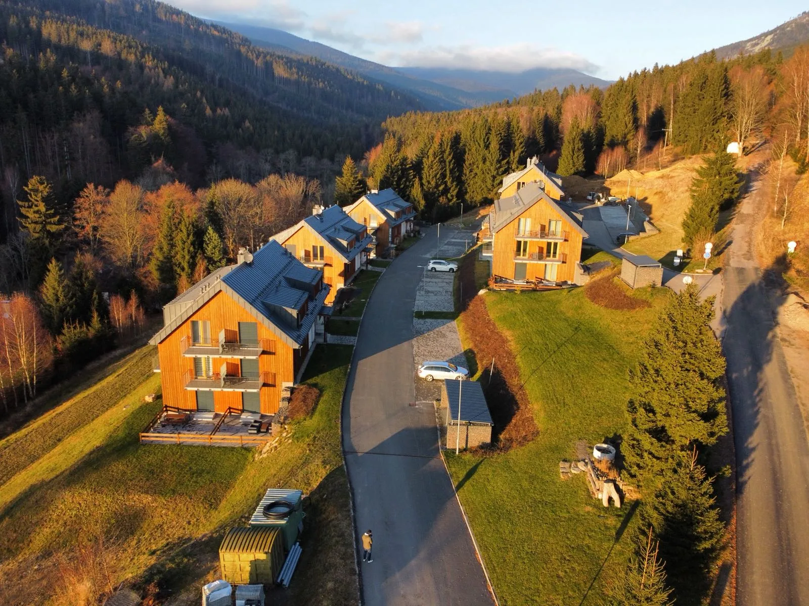 Apartmánový komplex LUEL v podvečerním slunci s výhledem na hory